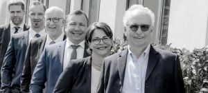 Die Wirtschaftsgutachter von WJU stehen auf einem Gruppenbild hintereinander