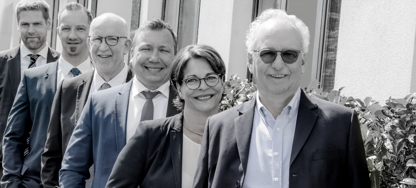 Die Wirtschaftsgutachter von WJU stehen auf einem Gruppenbild hintereinander